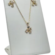 Set collar y aretes dorado de rodio con dije de flor